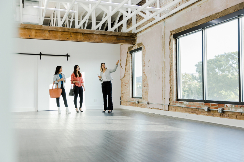 Real estate agent gestures while explaining office features to customers